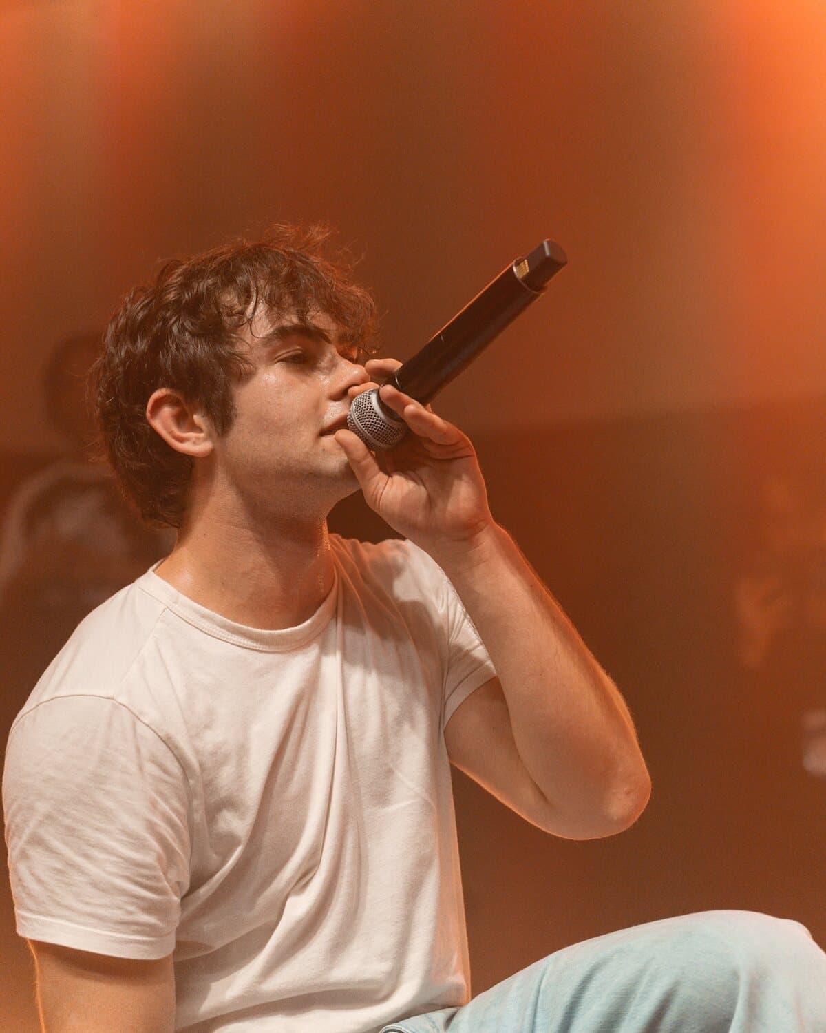 ian singing under warm light