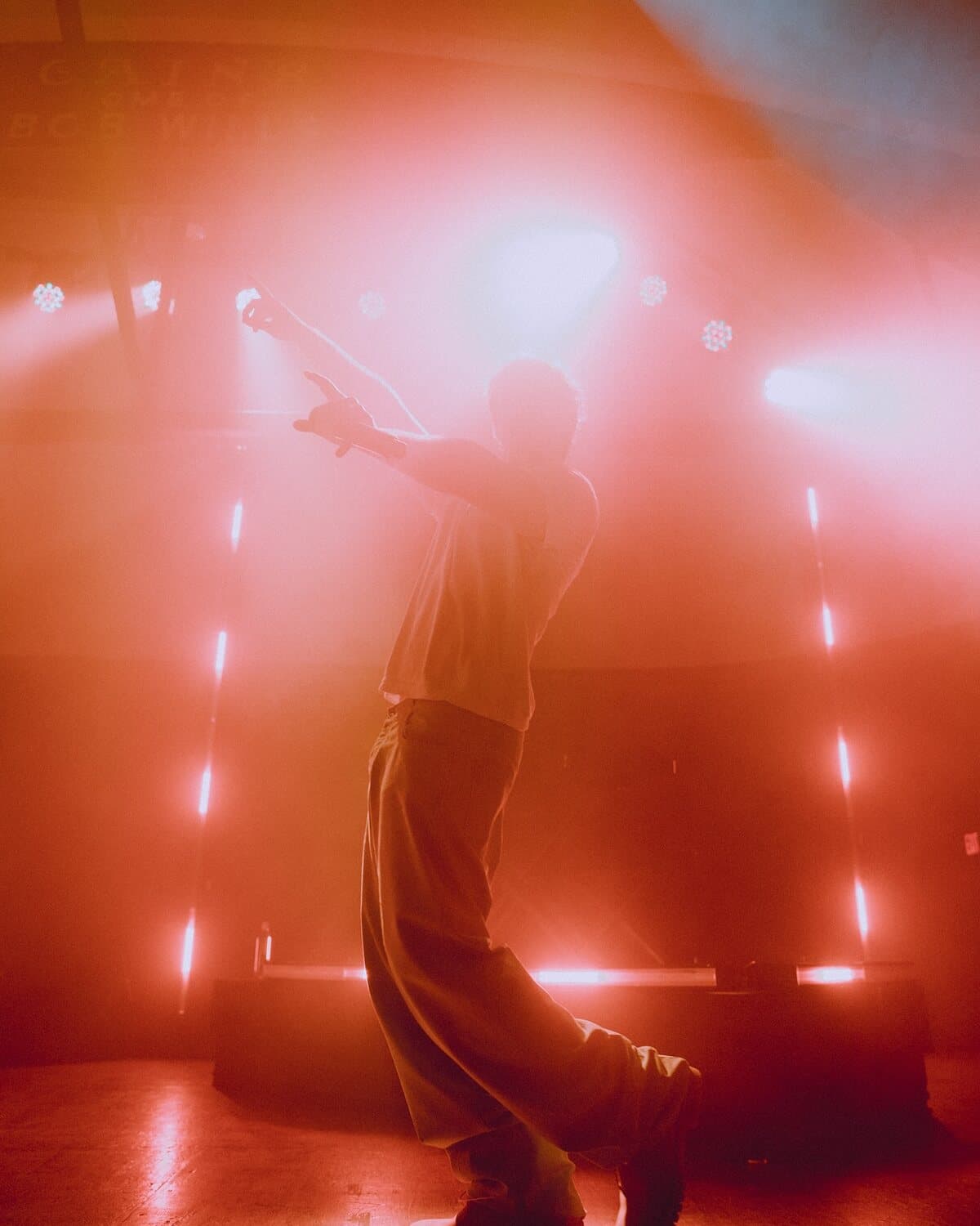 ian backlit by red stage lights
